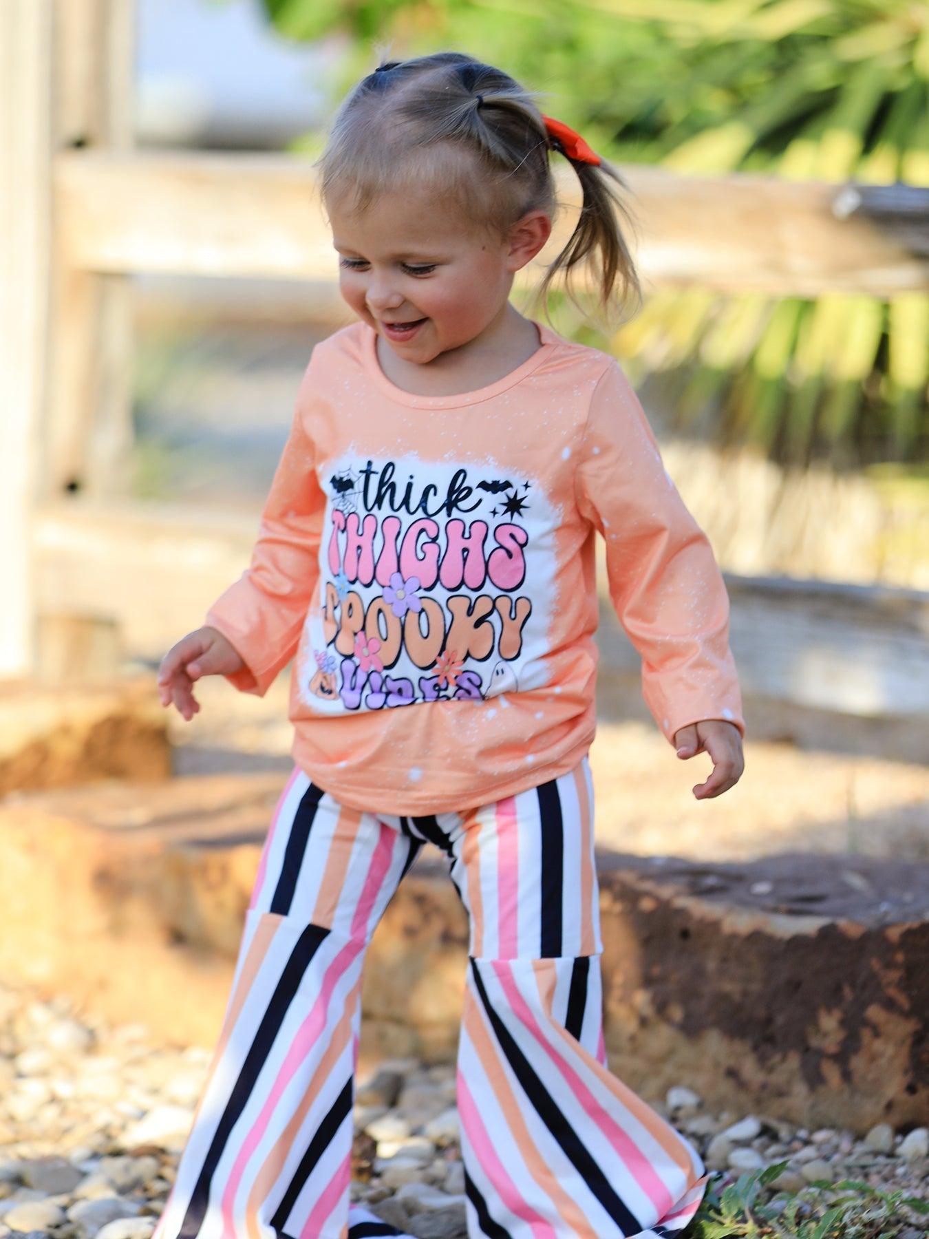 Two-piece outfit with a bleached Halloween letter top and striped flared pants.
