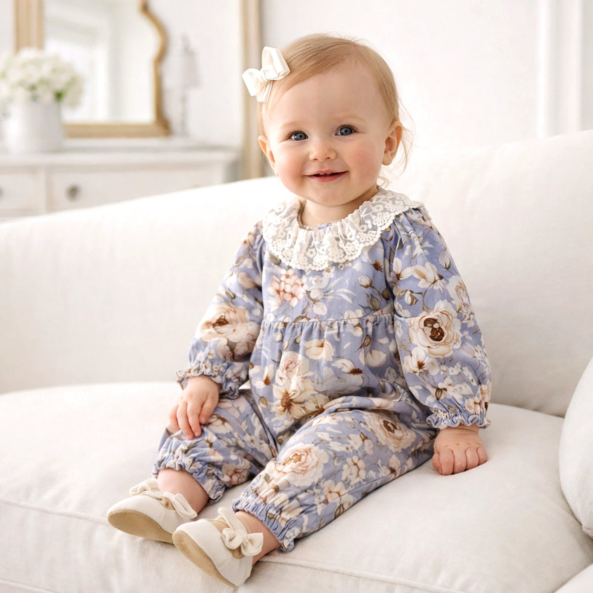 Baby romper in blue and cream floral print with scalloped lace collar, elasticized cuffs and ruffled leg hems