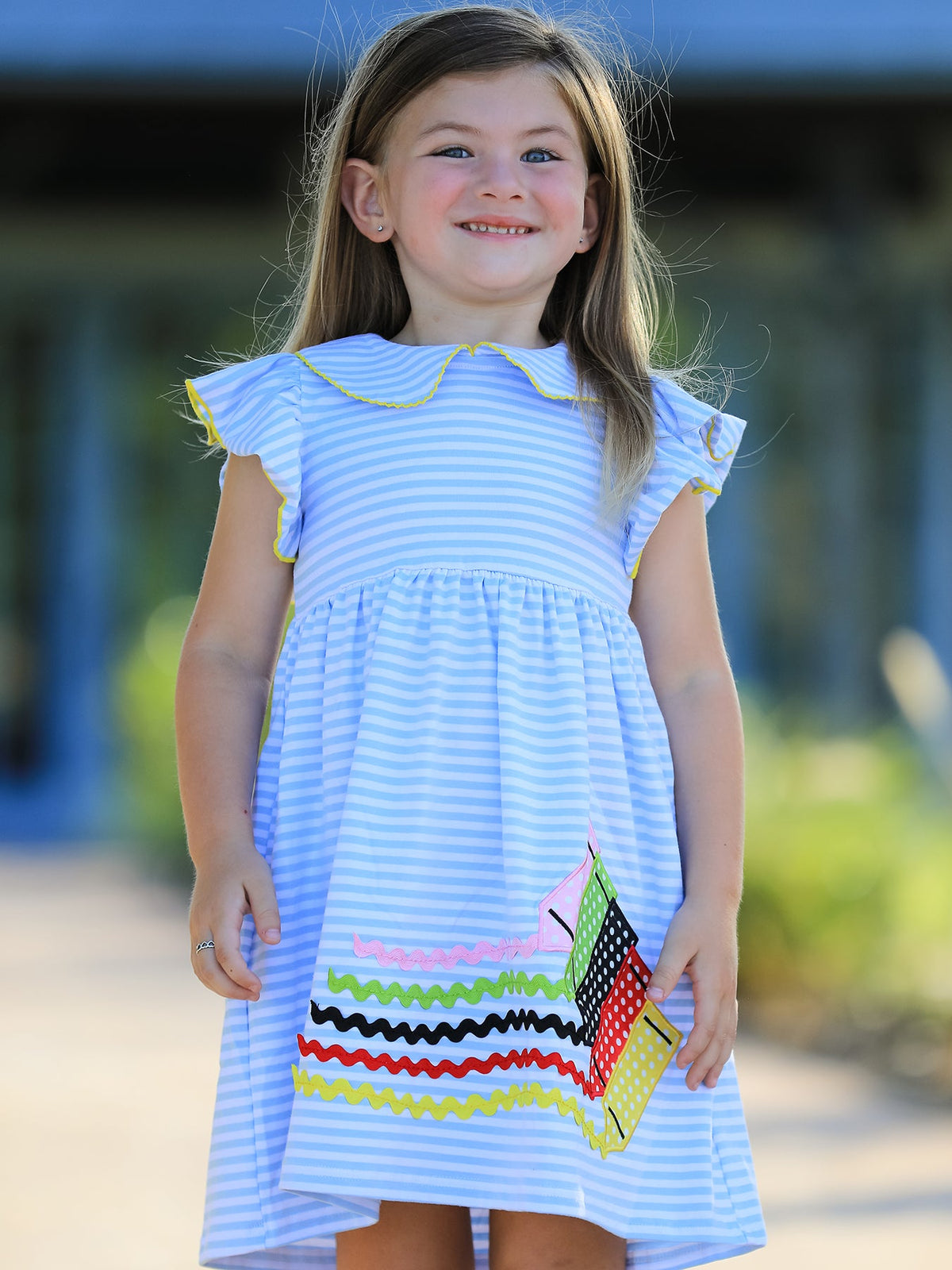 Girls dress with colorful crayon print and a pink ruffle petal collar with applique detail