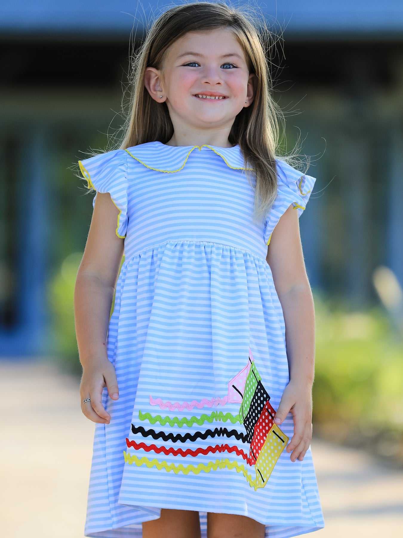 Girls dress with colorful crayon print and a pink ruffle petal collar with applique detail