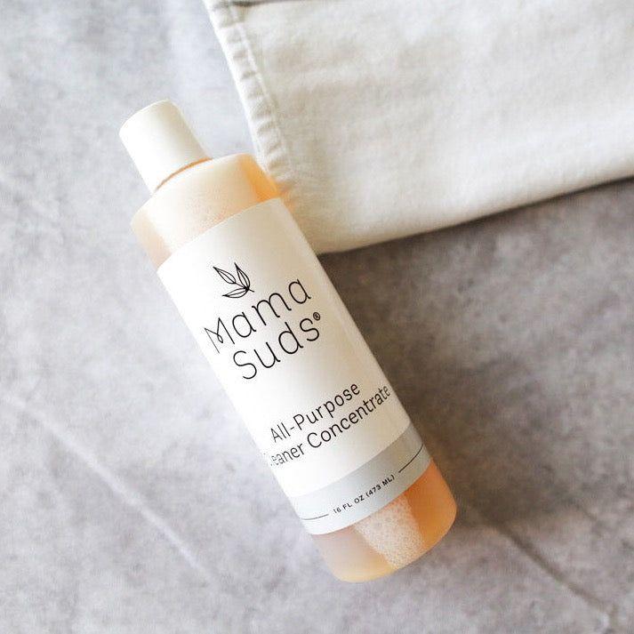 MamaSuds All-Purpose Cleaner Concentrate bottle on gray surface.