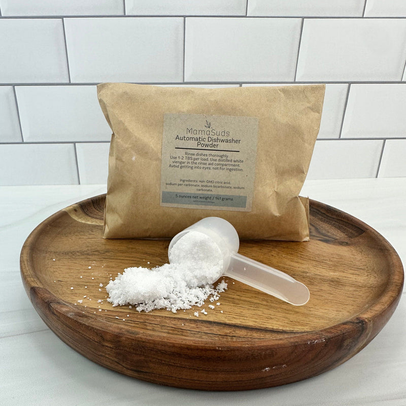 Automatic Dishwasher Powder sample with scooped powder on wooden tray.