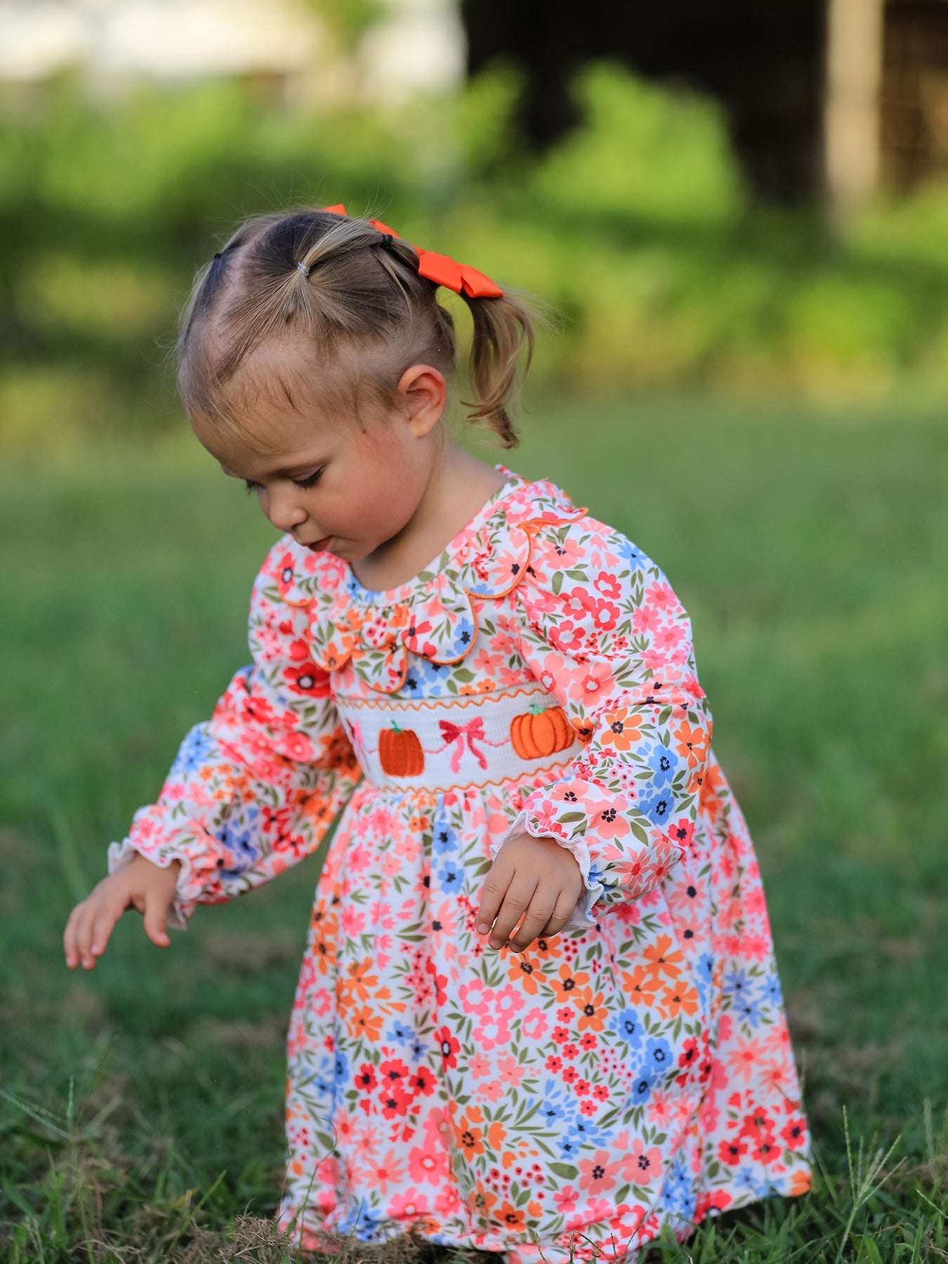 Smock dress with embroidered pumpkin bow details, styled for fall and Halloween.