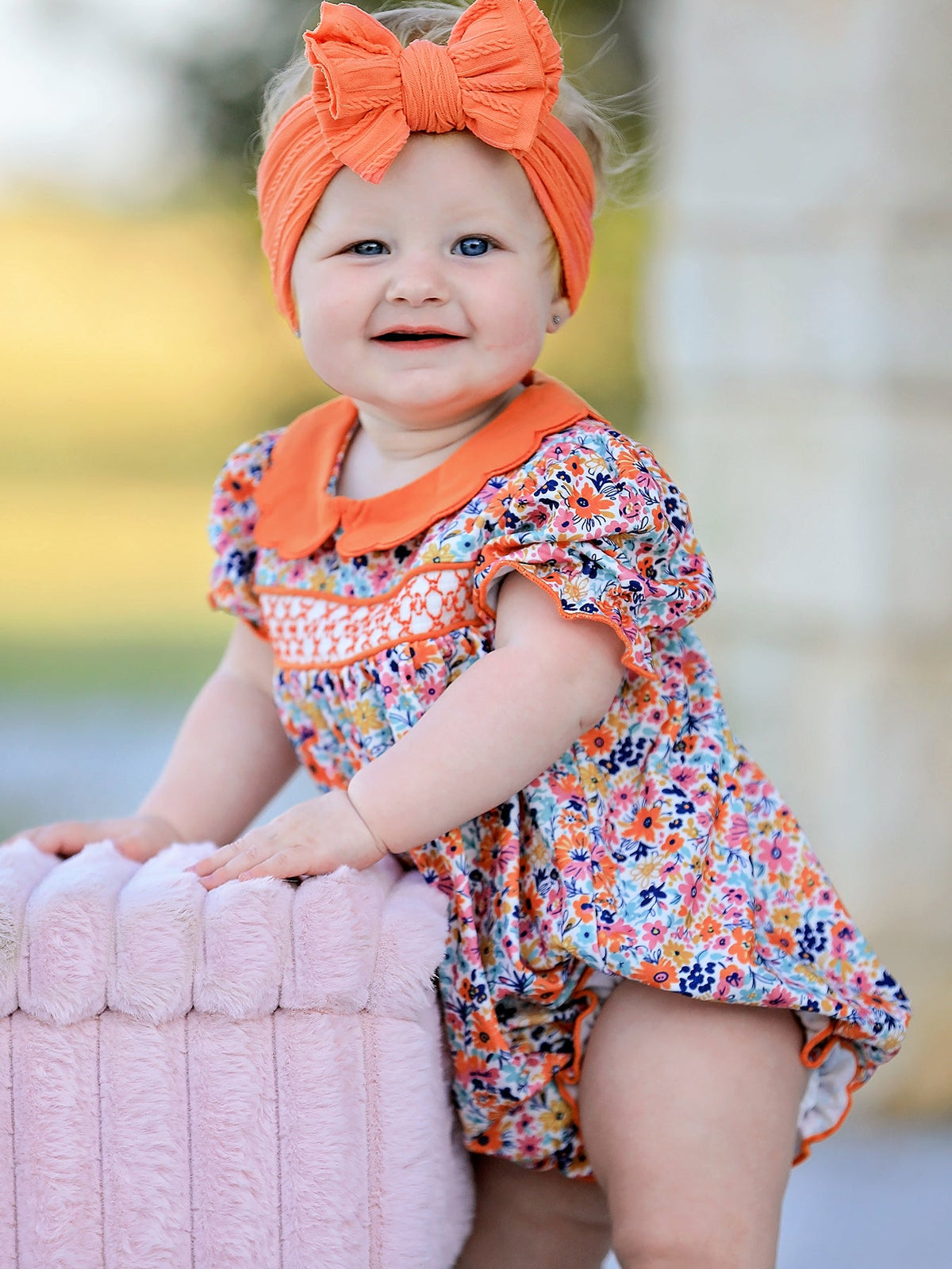 Floral bubble romper with smocked details, puff sleeves, and a contrasting petals collar
