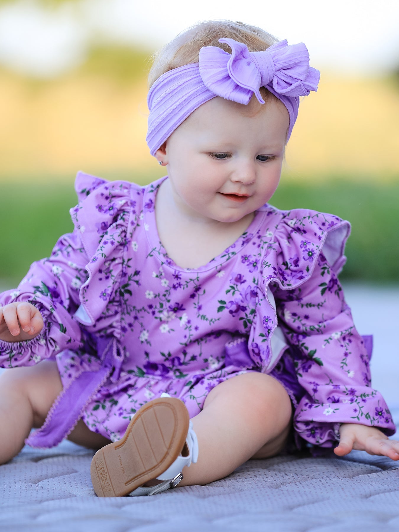 Long sleeve baby romper with all-over floral print and ruffle detail