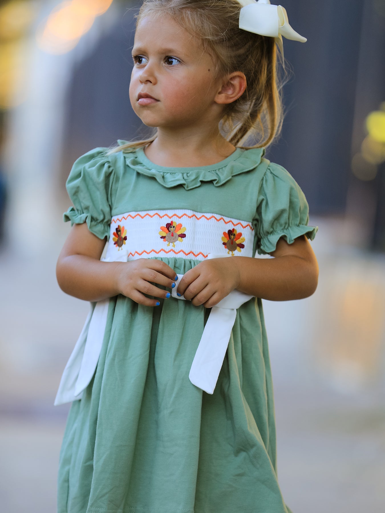 Green smock dress for baby girls with embroidered chicken design on the front