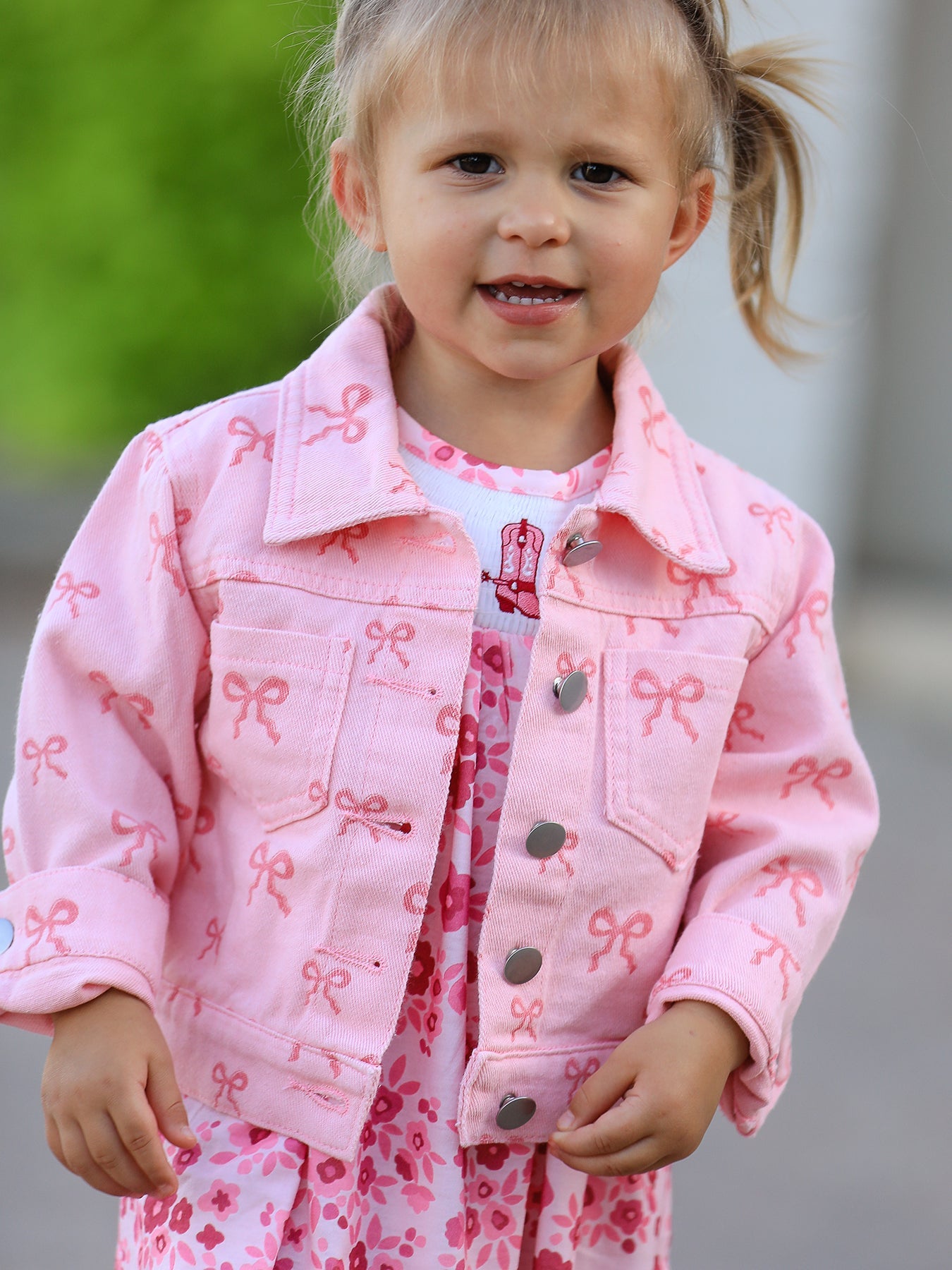 Pink denim jacket for girls with an all-over bow print.
