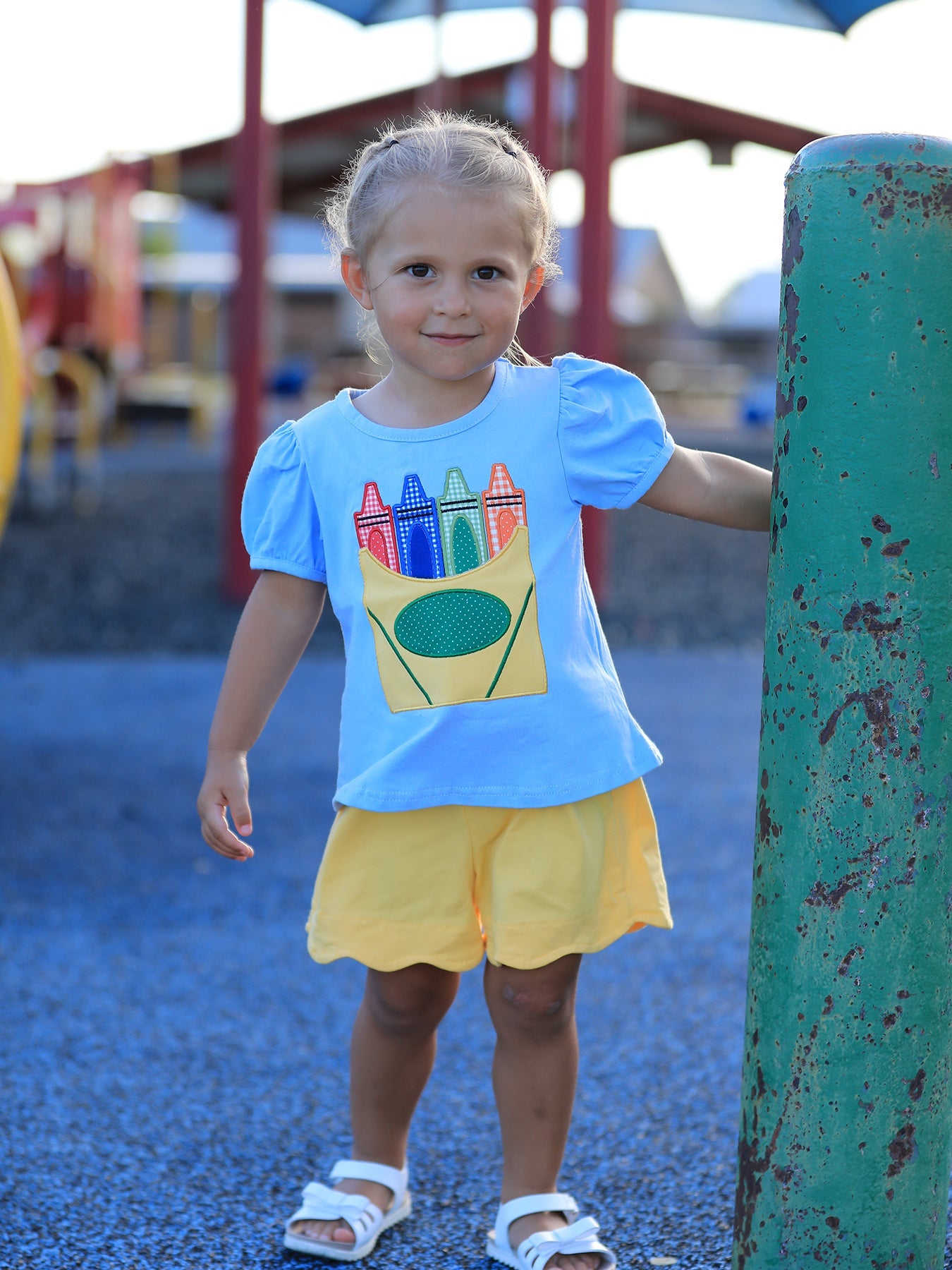 Girls two-piece set with a crayon applique puff sleeve top and solid scalloped hem shorts.