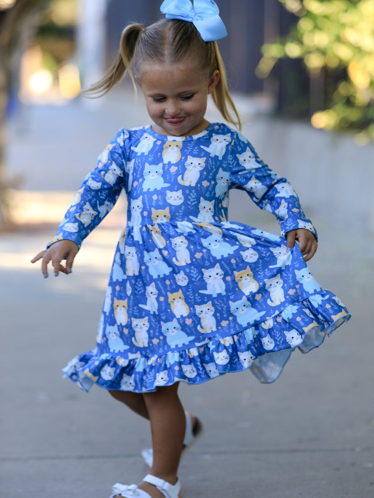 Long sleeve girls' dress with allover fall cat print and ruffle hem, shown in a flowy silhouette