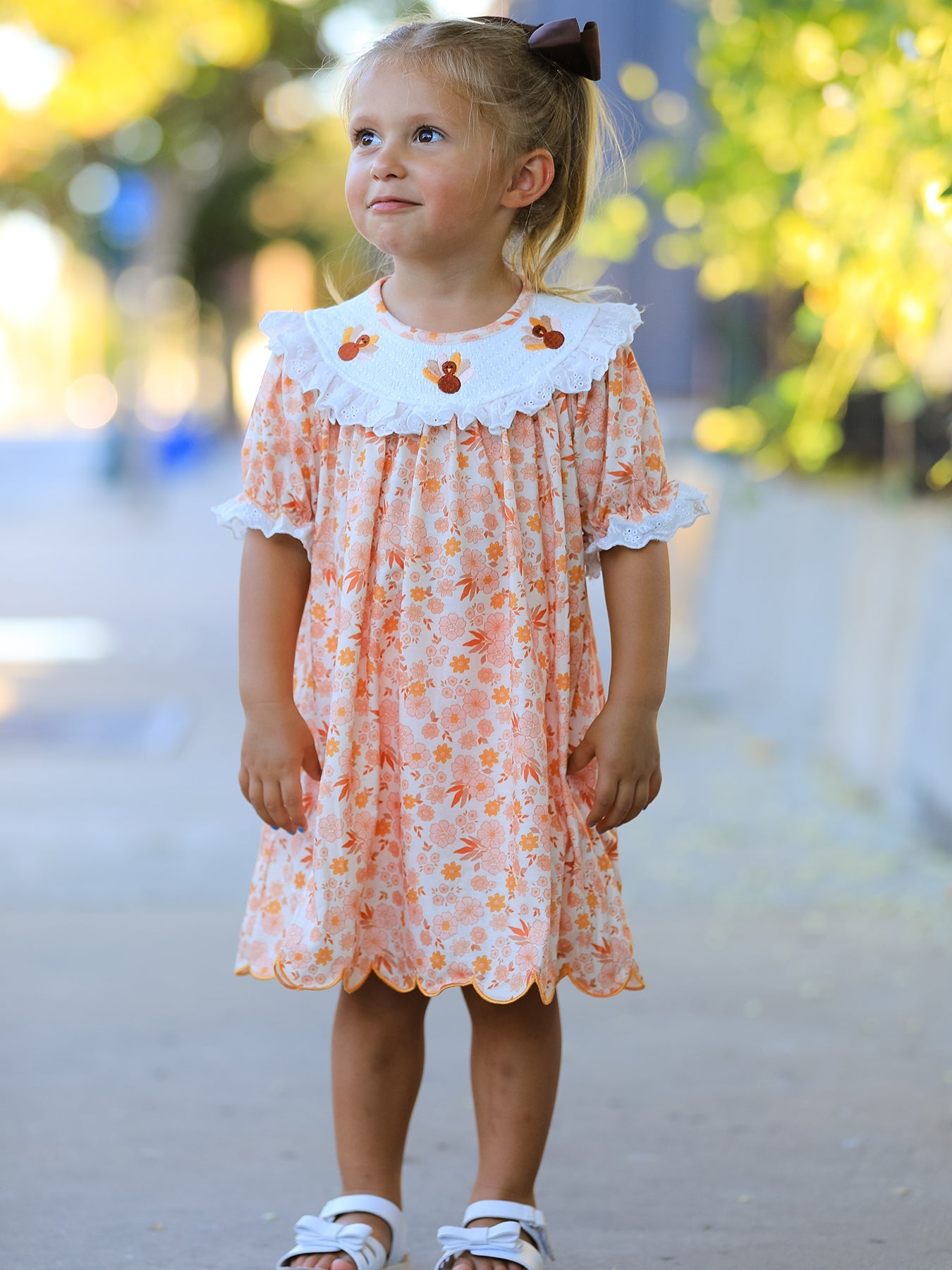 Girls dress with floral print, embroidered turkey details, lace ruffle yoke, puff sleeves and scalloped hem