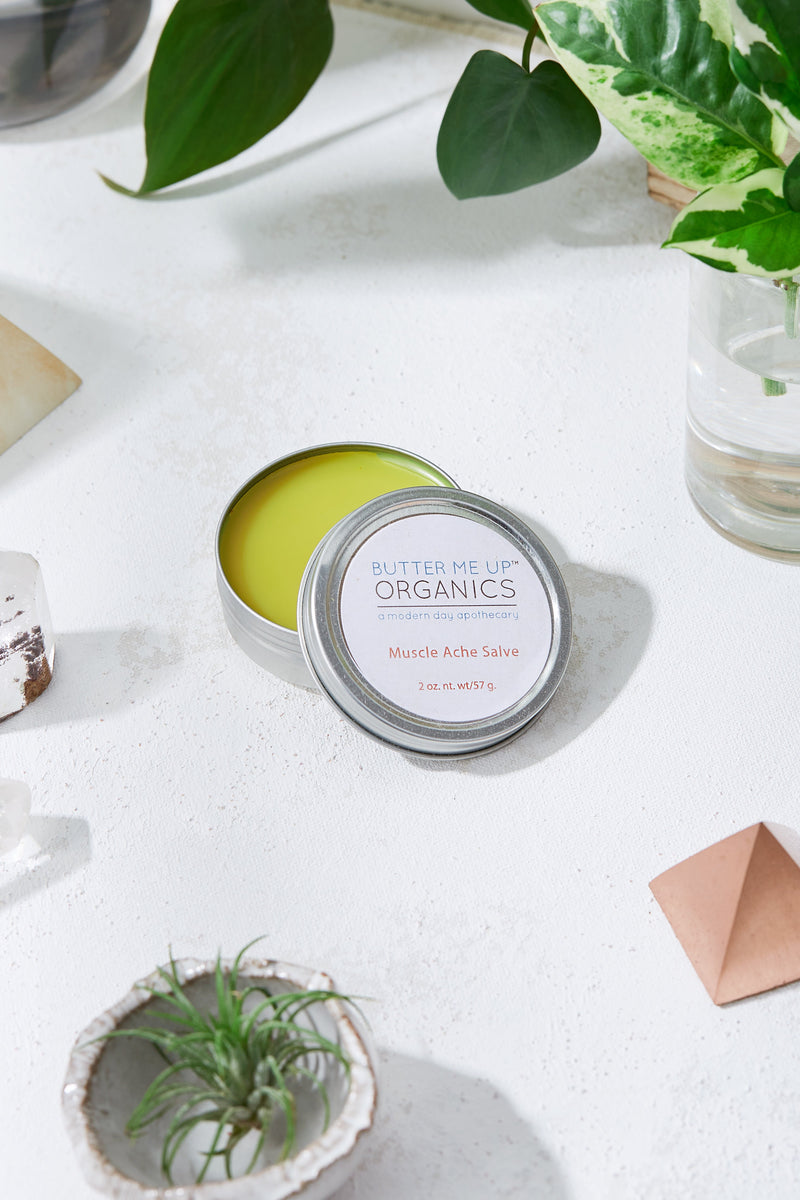 Organic muscle ache salve in tin, plastic-free, with natural pain-relieving ingredients like cayenne and turmeric.