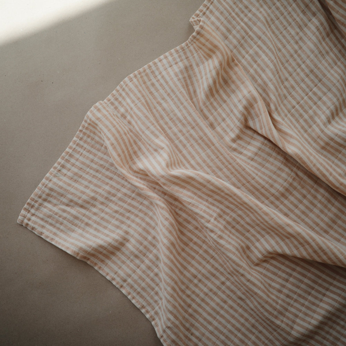 Soft, breathable Mushie organic cotton muslin baby swaddle blanket.