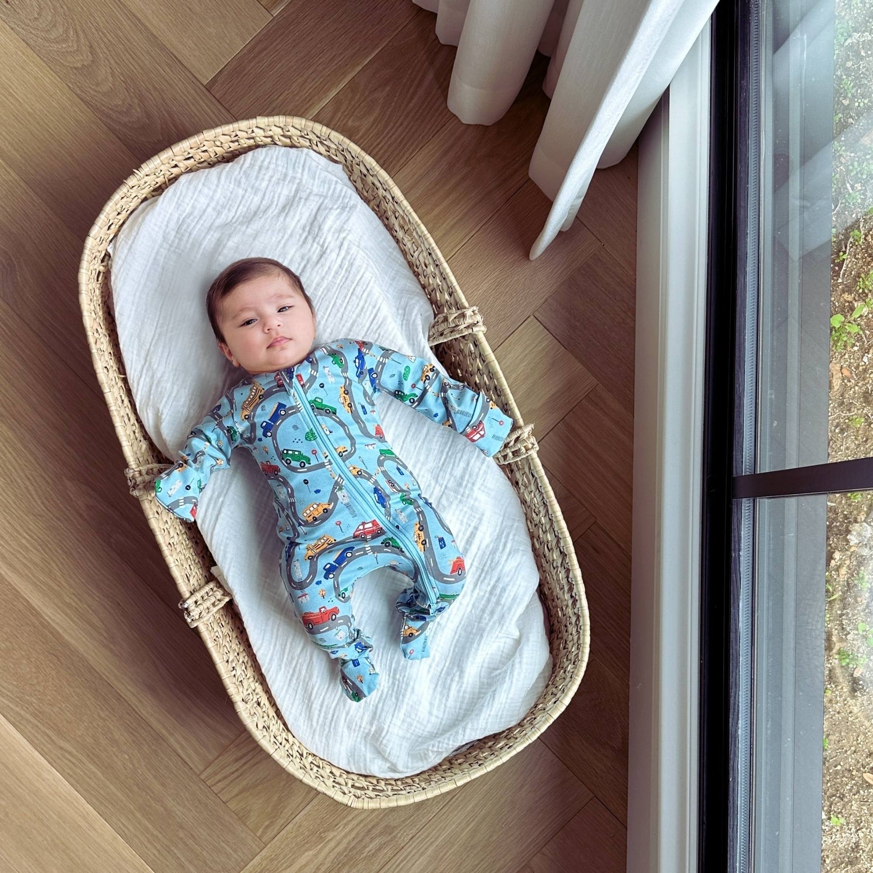 Norani Baby organic footie pajamas with colorful car print.