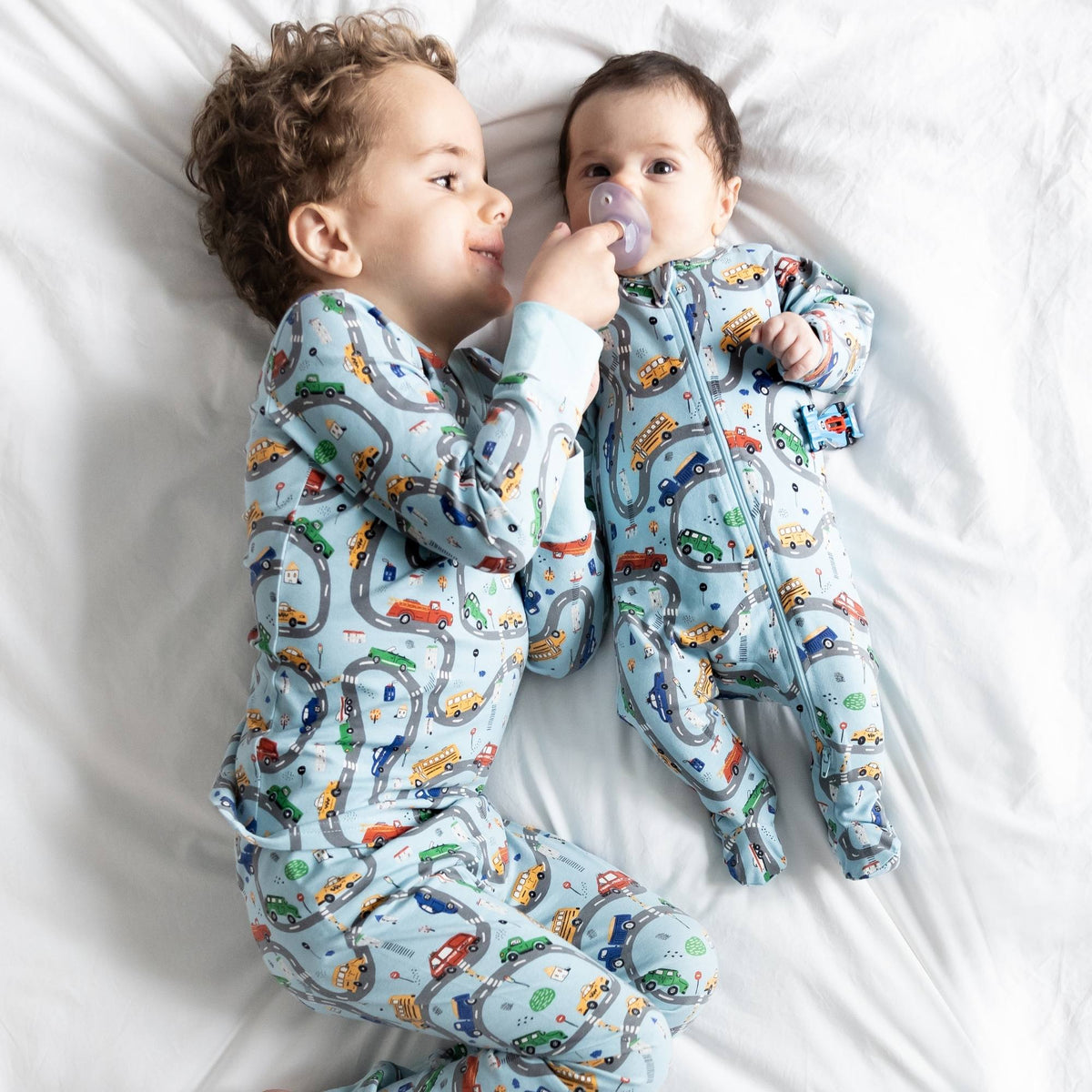 Norani Baby organic baby footie with a fun car print.