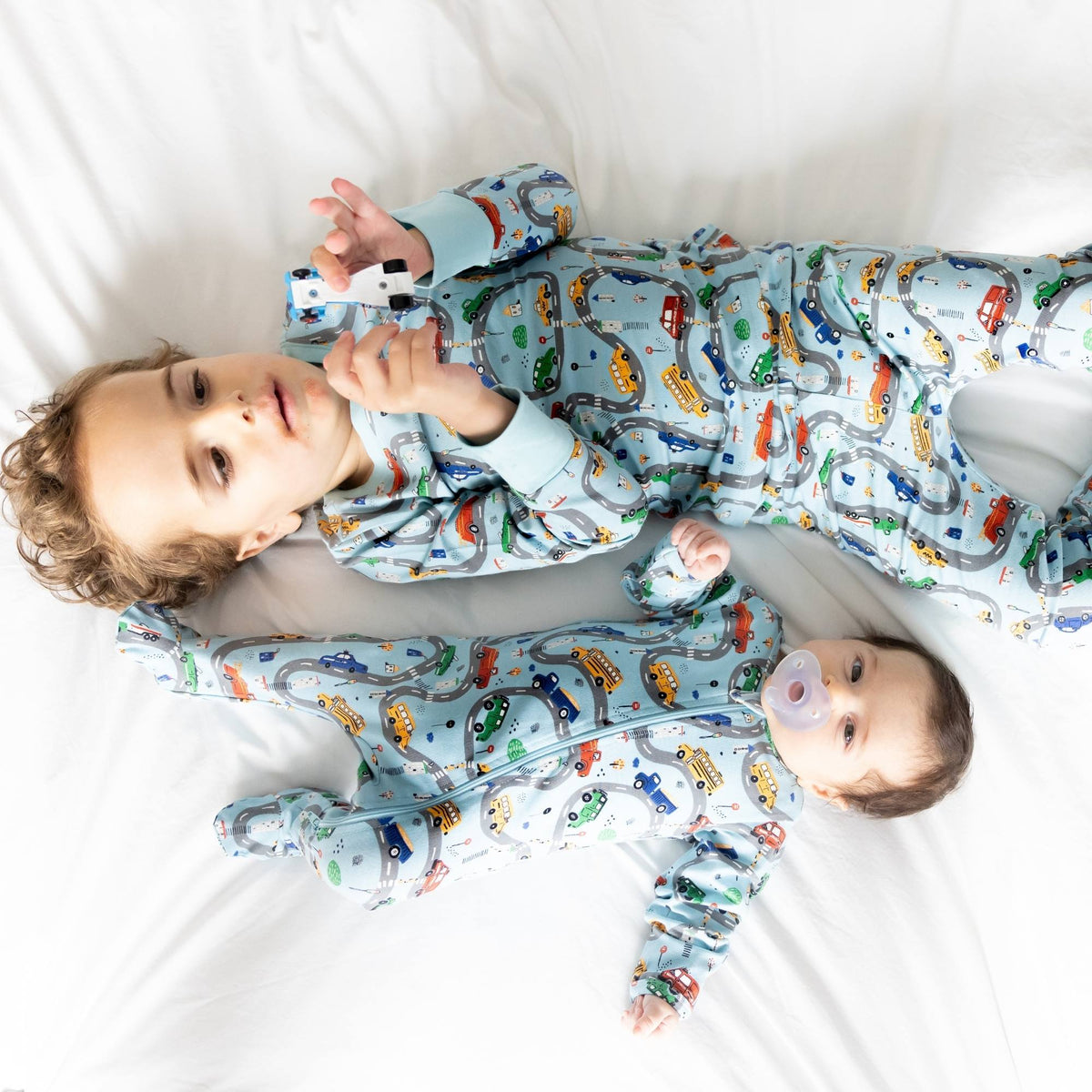 Norani Baby organic footie pajamas with colorful car print.