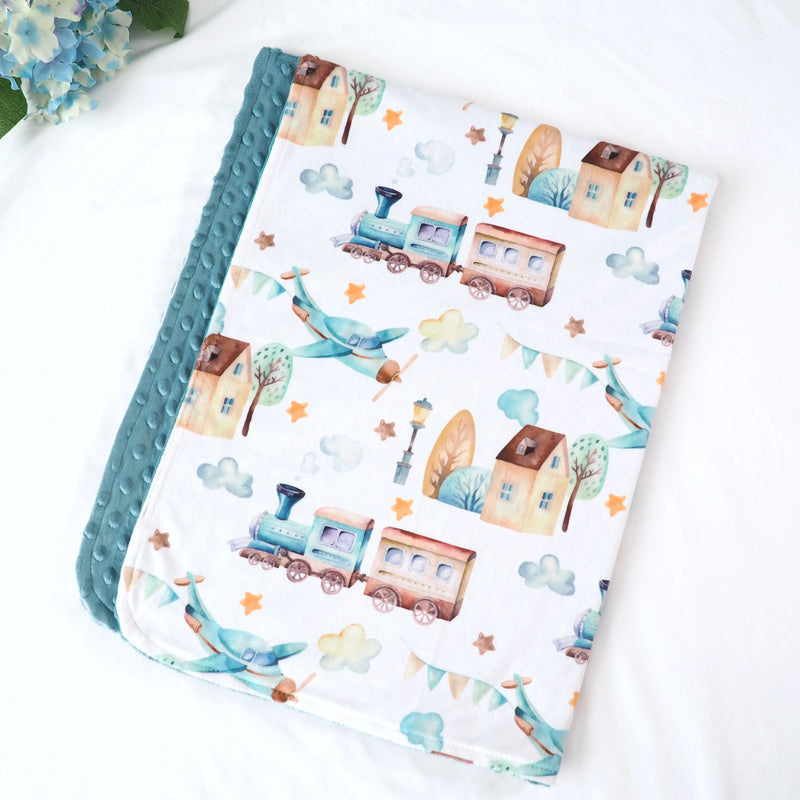 Premium baby and toddler minky blanket with planes, trains, and automobiles design, featuring a vintage, colorful pattern and soft texture for sensory stimulation.