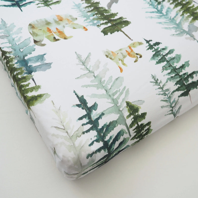 Woodland-themed changing pad cover with soft fabric and forest bear design.