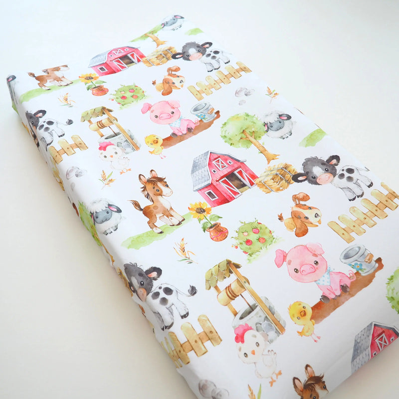 Changing pad cover with colorful farm animal design.