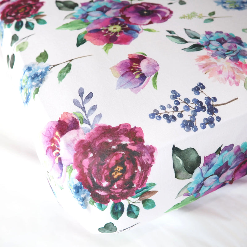 Blue floral fitted crib sheet with vibrant floral patterns.