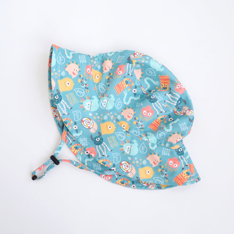 Colorful kids' sun hat with fun monster print, lightweight polyester fabric.