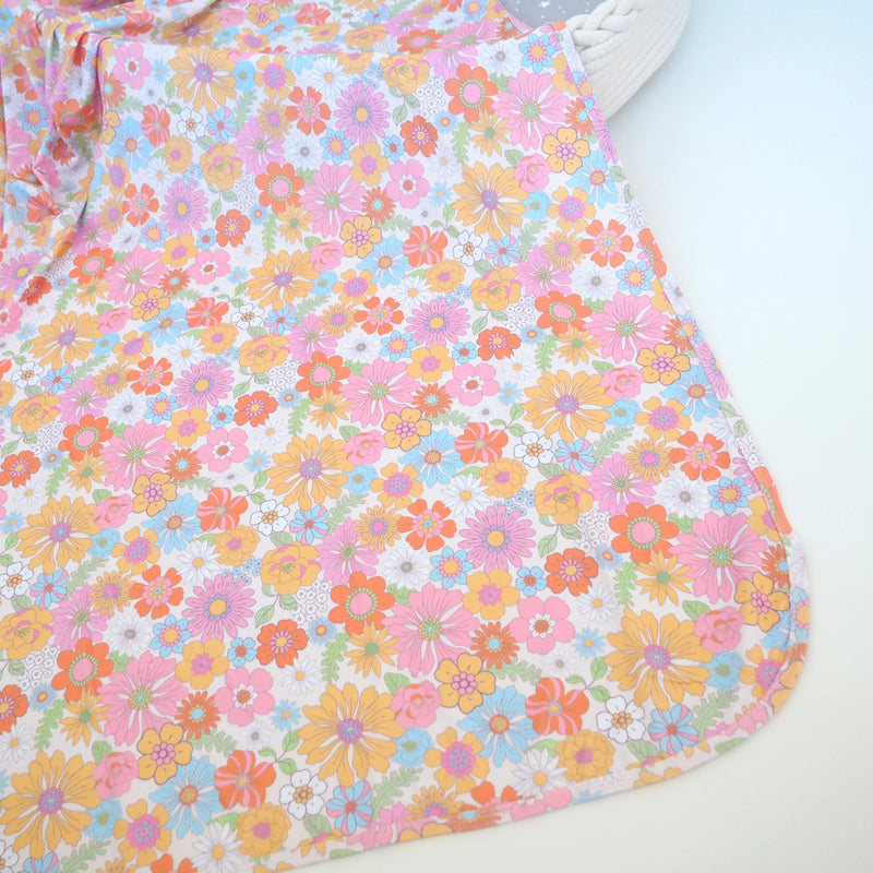 Buttery soft and stretchy swaddle blanket with retro floral pattern.