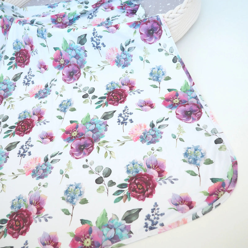 Buttery soft and stretchy swaddle blanket with blue floral design.
