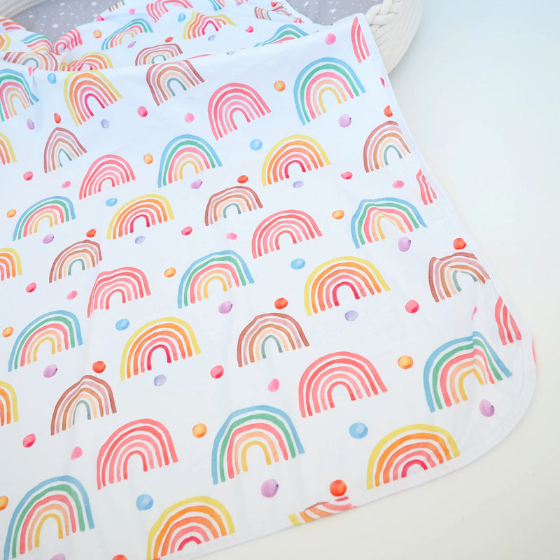 Buttery soft and stretchy swaddle blanket with rainbow pattern.