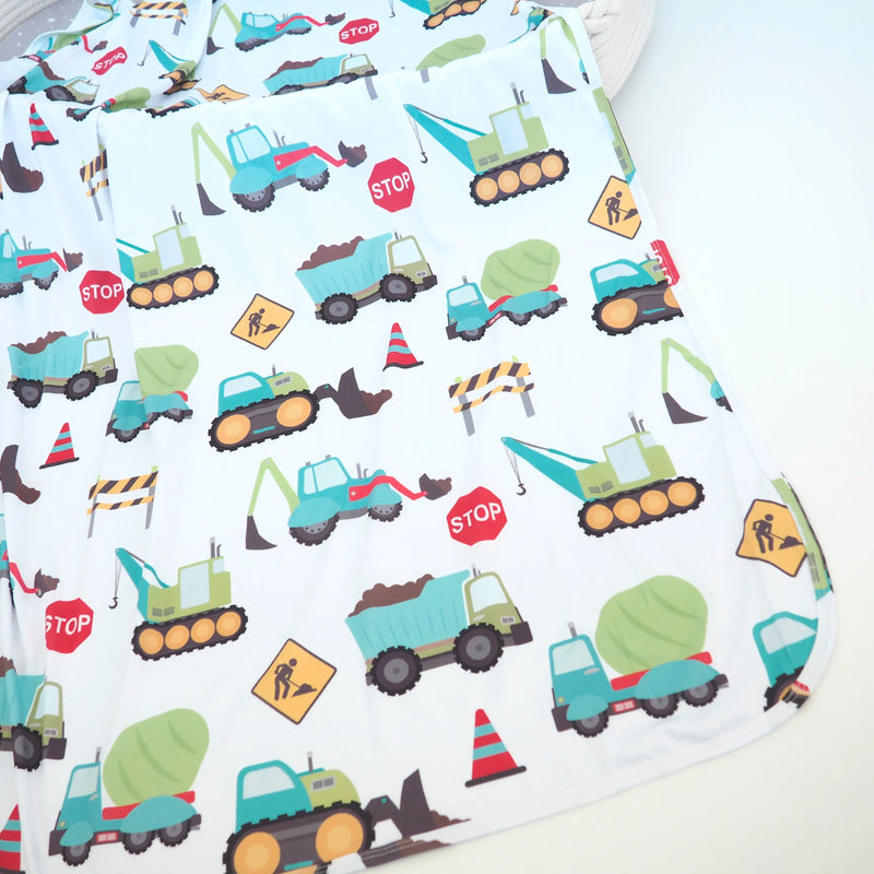 Buttery soft and stretchy swaddle blanket with construction truck pattern.