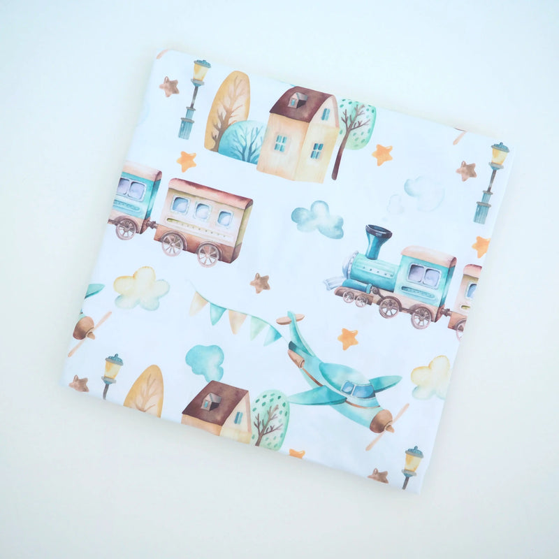 Buttery soft and stretchy swaddle blanket with airplane and train pattern.