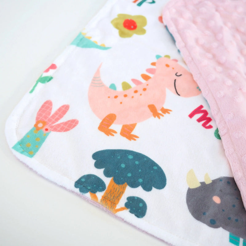 Mini Minky blanket in Dinoland Pink design featuring colorful dinosaurs and Minky dot texture for toddlers.