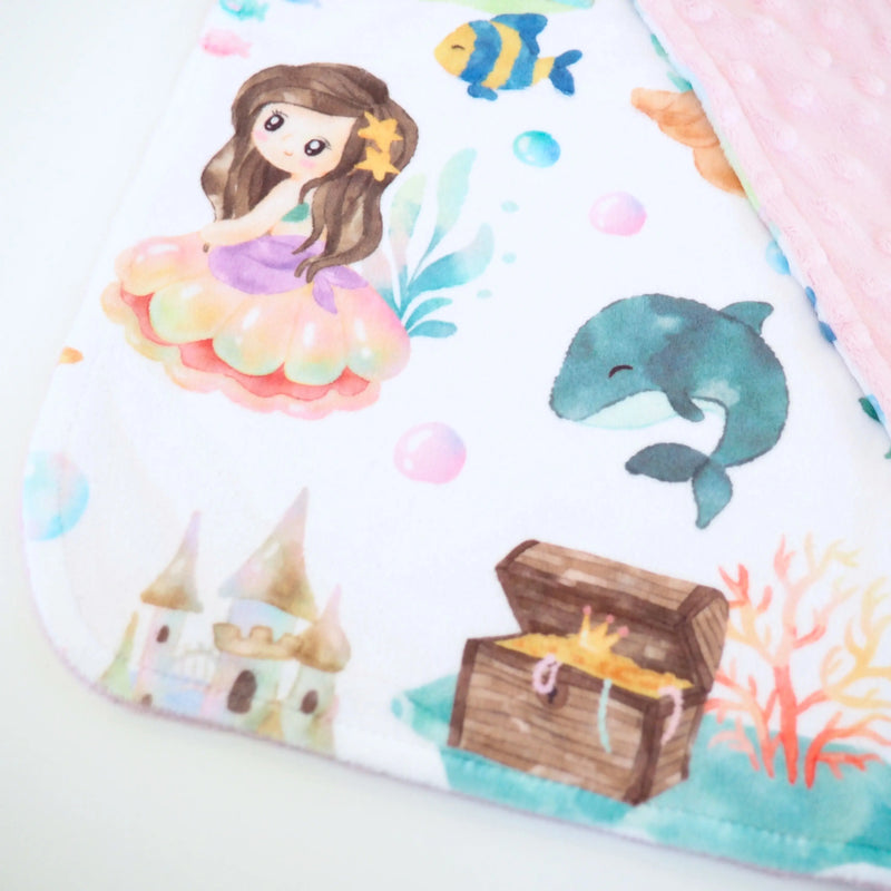 Mini Minky mermaid-themed toddler blanket with soft pink Minky dot texture, ideal for travel and sensory play.