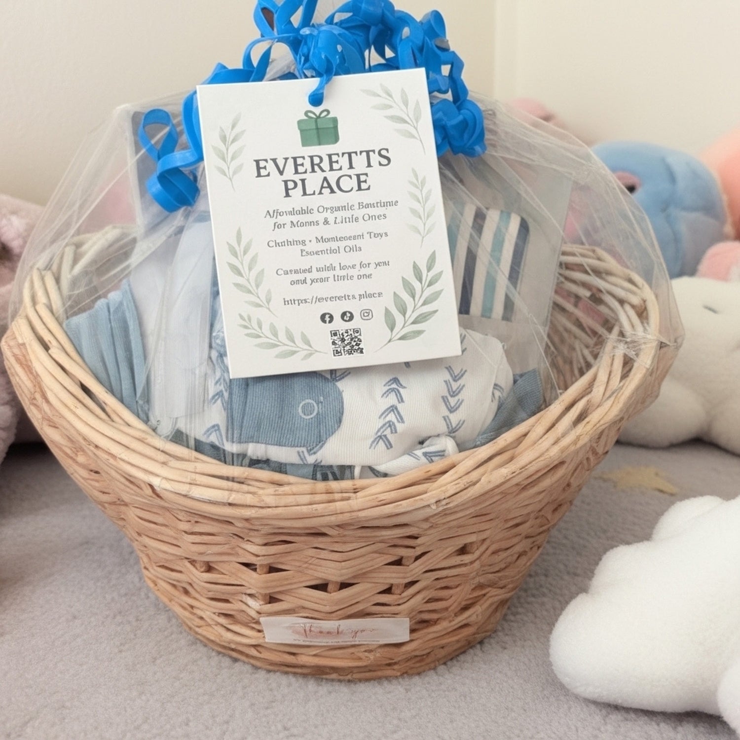 Basket with baby items and a 'Everett's Place' tag on a soft surface.