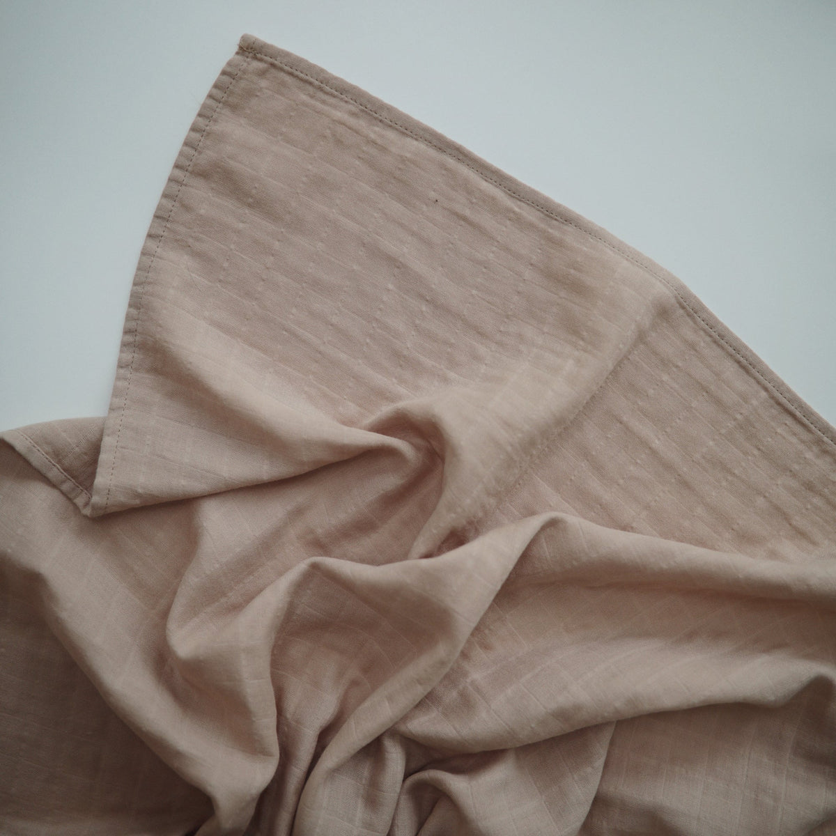 Mushie organic cotton muslin swaddle blanket for baby.