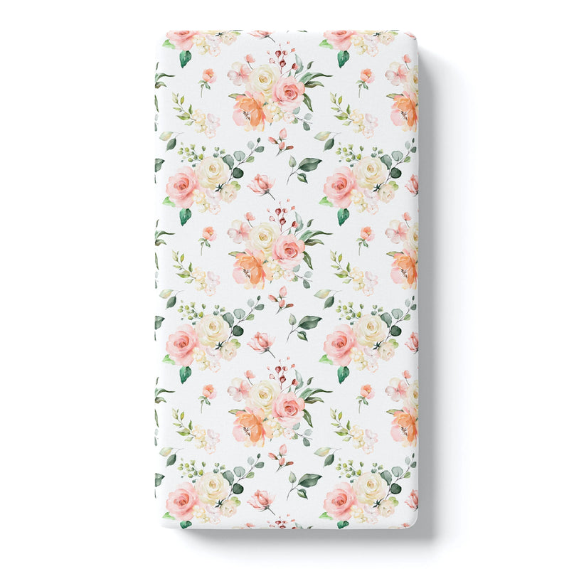 Peach floral fitted crib sheet with soft fabric.