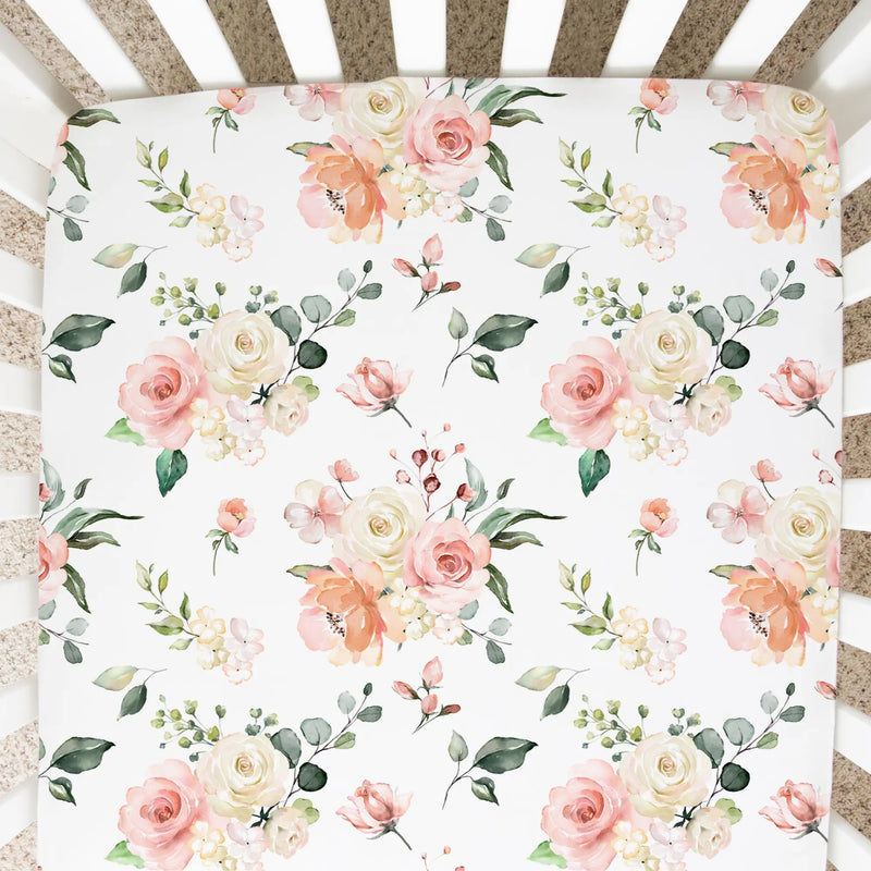Peach floral fitted crib sheet in crib, soft and stylish bedding for nursery.