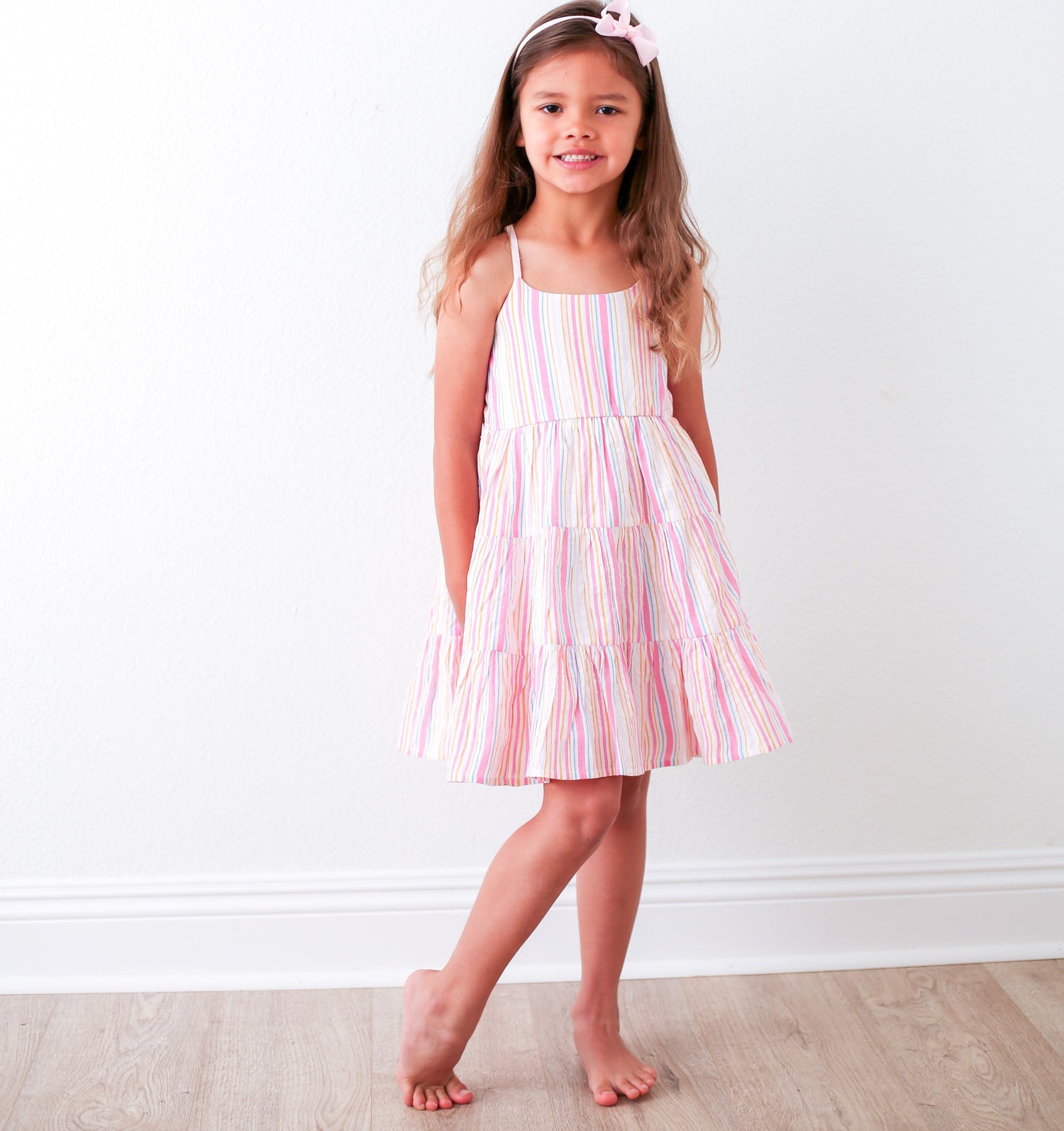 Baby girl dress with vibrant stripes, a flowy skirt, and a racer back.