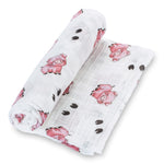 Swaddle blanket in organic cotton muslin with a pig and hoof print in the Oink Oink design