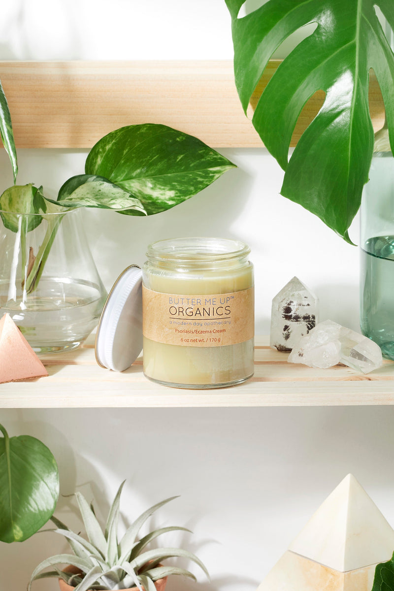 Sensitive Skin Cream jar with organic ingredients on a wooden shelf near plants.