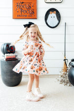 Girls' 3/4 sleeve twirl dress in pumpkin print with pockets and a full twirl skirt