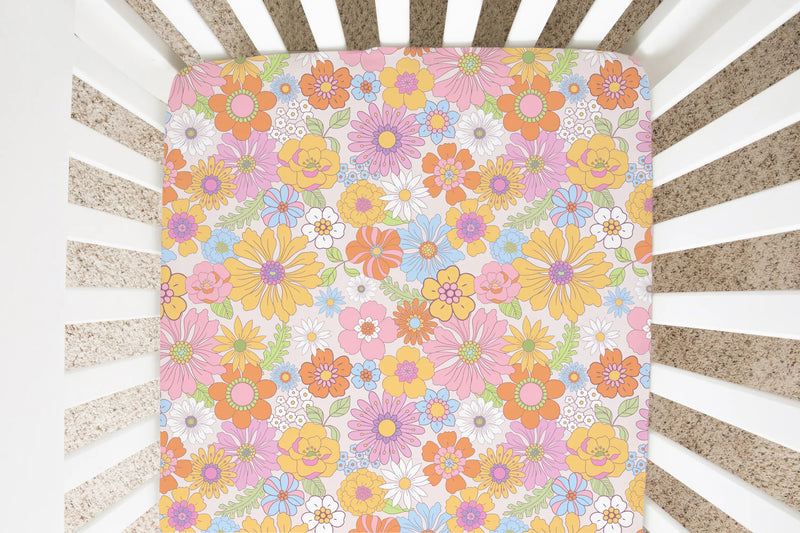 Retro floral fitted crib sheet on a crib mattress.