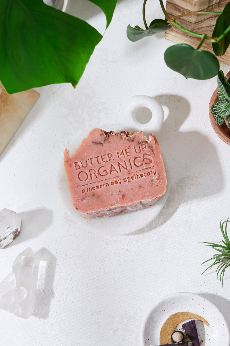 Rose Garden Organic Soap with rose petals and pink clay on a white background.