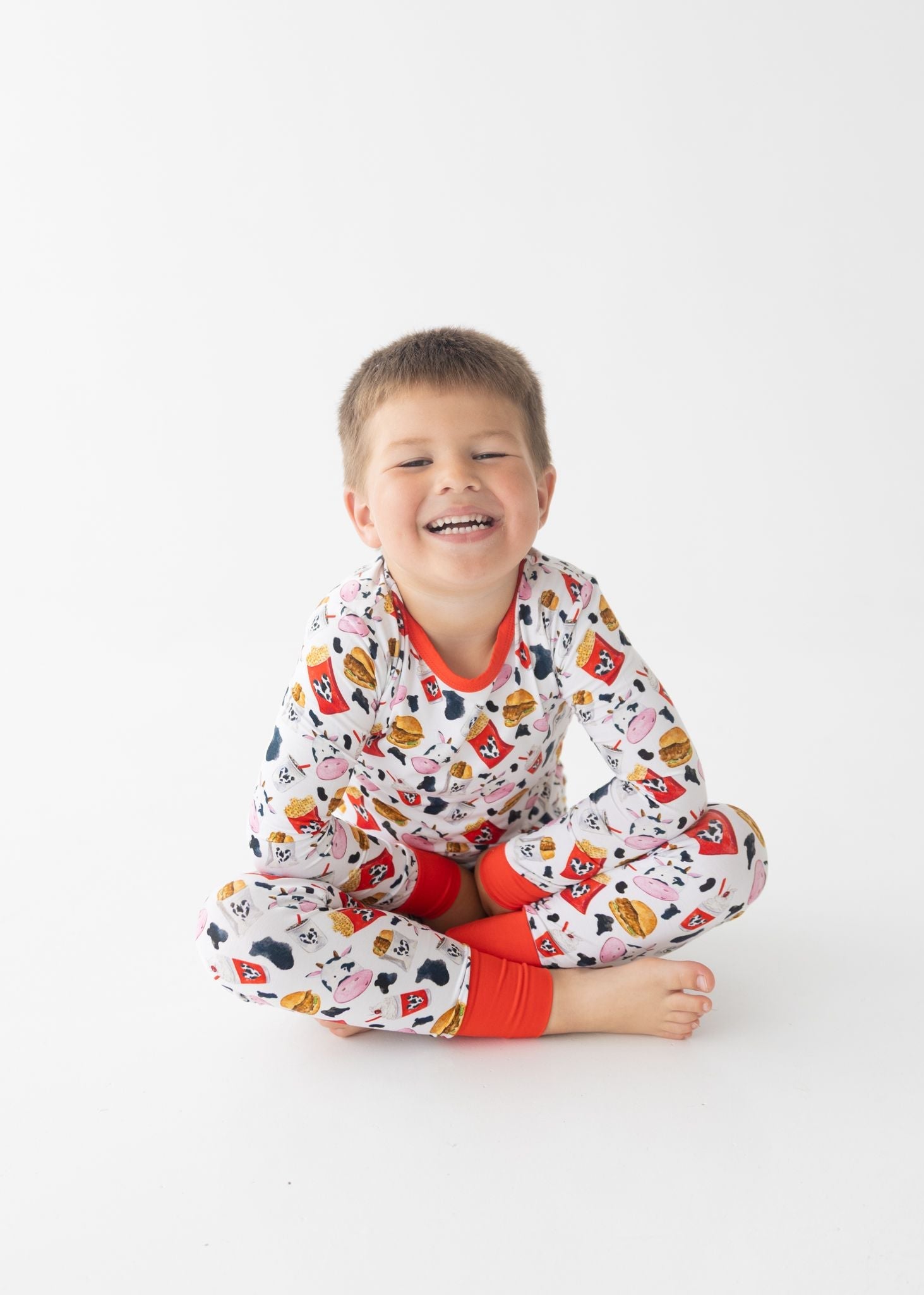 Toddler pajama set with matching top and pants printed with chicken nuggets, fries, and milkshakes.