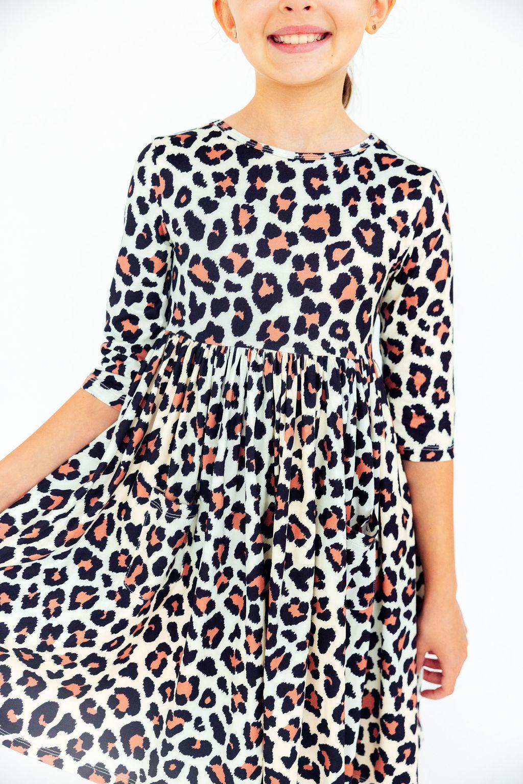 Girls' 3/4 sleeve twirl dress in the Wild One print with a full skirt and side pockets.