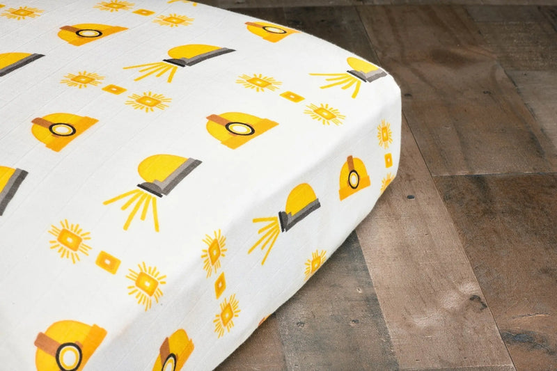 Bamboo muslin crib sheet with hard hat pattern on a standard mattress.