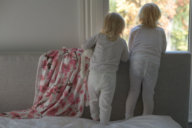 Cherry Blossom Bamboo Muslin Newcastle Blanket with children by a window.