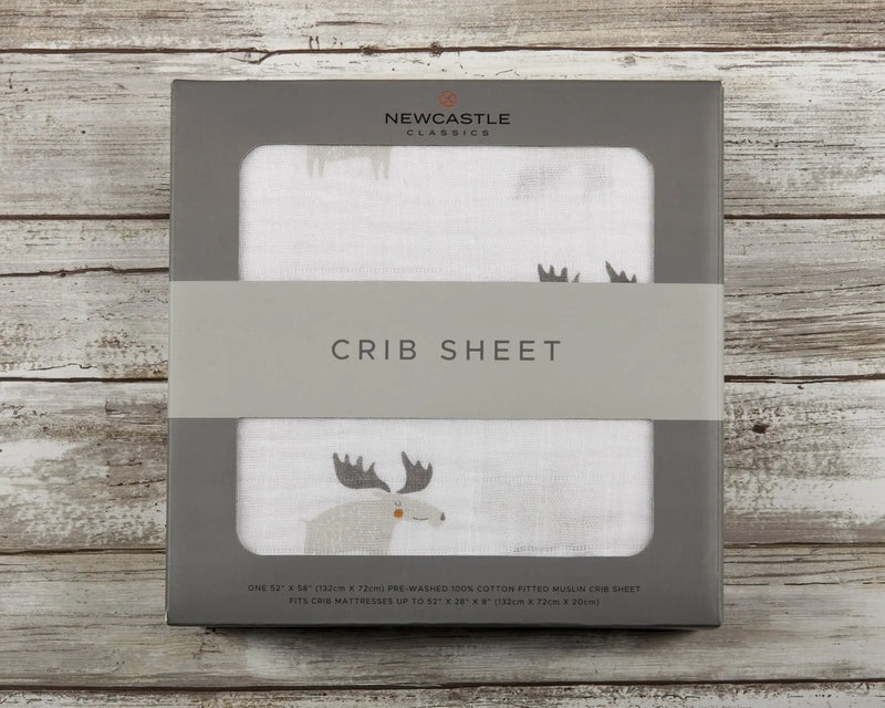 Mister Moose Cotton Muslin Crib Sheet in package on wooden surface.