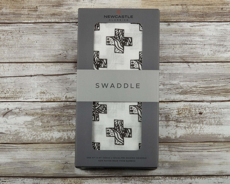 Nordic Stamp Bamboo Muslin Swaddle in packaging on wooden background, 100% natural bamboo fibers.