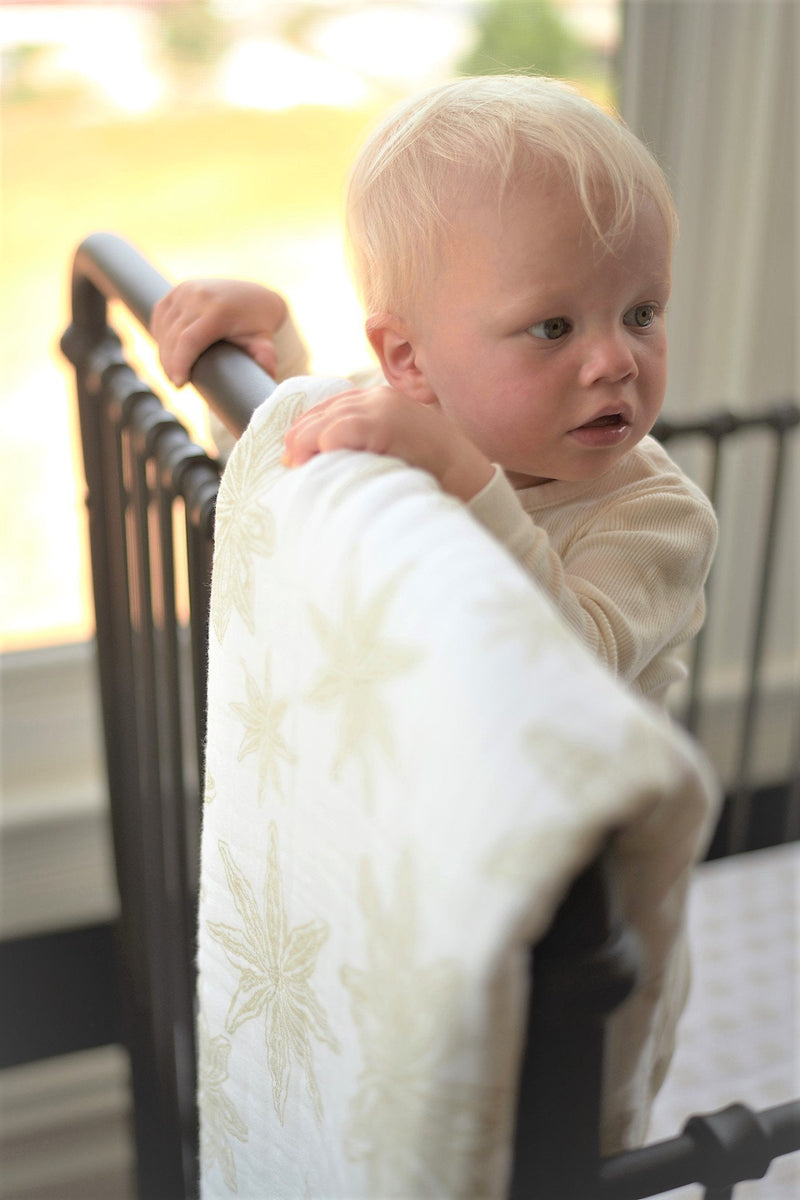 Boho Fields Cotton Muslin Newcastle Blanket with baby in crib.