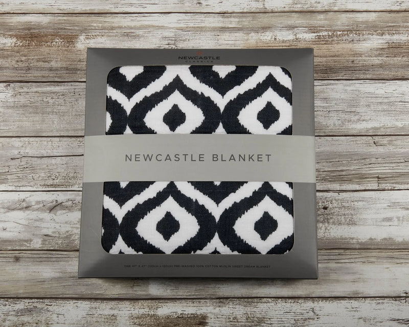 Moroccan Blue Cotton Muslin Newcastle Blanket in packaging with black and white geometric pattern.