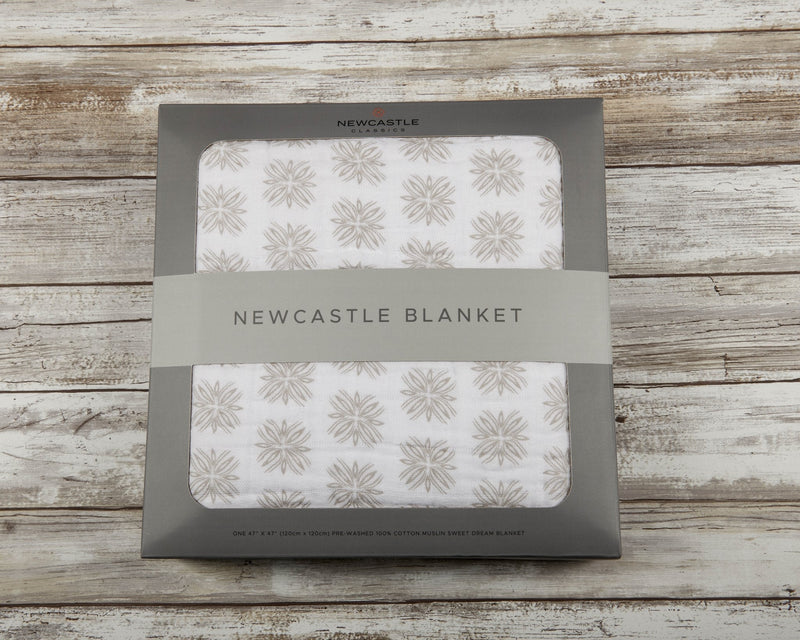 Flower Child Cotton Muslin Newcastle Blanket in packaging, featuring a soft floral pattern on natural cotton fabric.